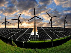 A landscape featuring solar panels and wind turbines under a dramatic sky.